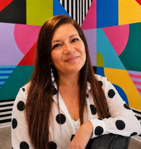 Retrato de Solangel Rodríguez sonriendo frente a un mural colorido, especialista en estrategia, marketing y comunicación en Pesquisa Estudio.